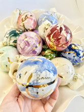 Load image into Gallery viewer, Colorful marbled balls with gold accents held by a hand against a light background
